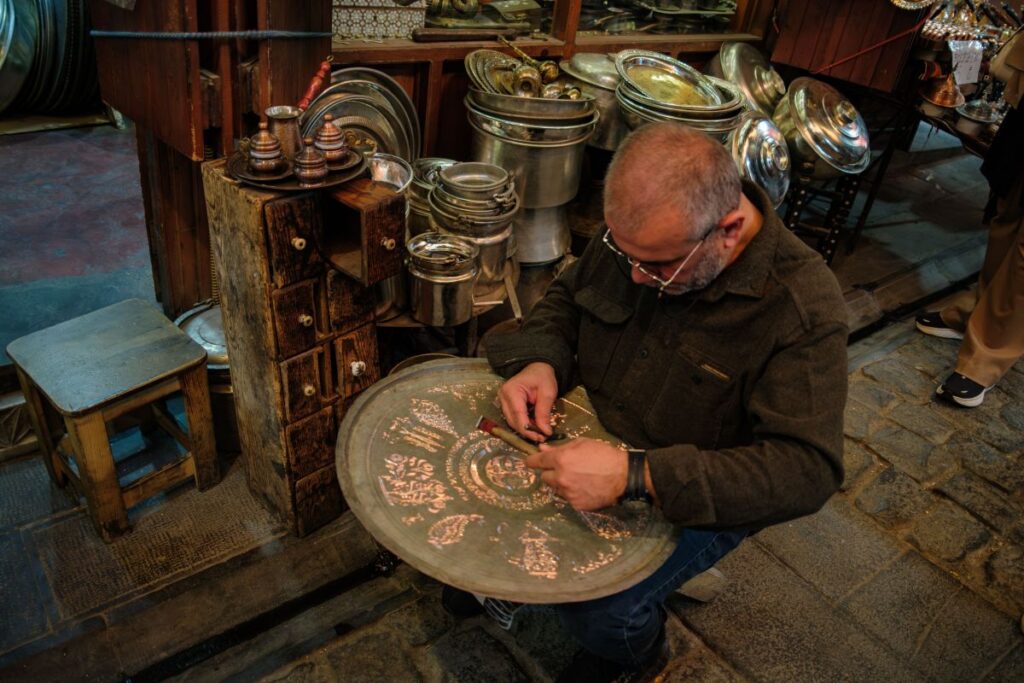Traditional coppersmith crafting handmade copperware in Gaziantep Bazaar